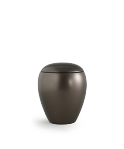 Eine matte, dunkelgraue, runde Urne mit aufgesetztem Deckel, die auf einer weißen Fläche vor einem einfarbigen Hintergrund steht. Aurora Tierkrematorium