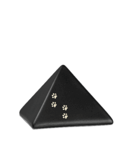 Schwarzes pyramidenförmiges Objekt mit kleinen goldenen Pfotenabdrücken auf einer Seite, vor einem schlichten weißen Hintergrund. Aurora Tierkrematorium