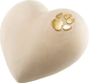 Herzförmiges Objekt mit glatter beiger Oberfläche und goldenen Pfotenabdrücken in der rechten oberen Ecke. Aurora Tierkrematorium